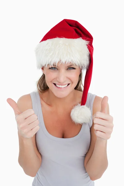 親指とクリスマスの帽子を持つ女性の肖像画 ロイヤリティフリーのストック写真