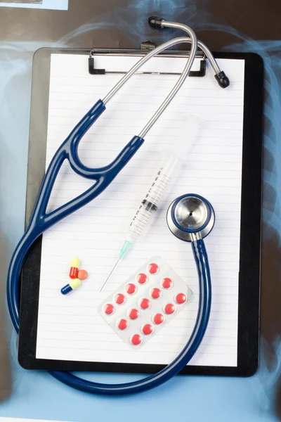 Stock image Note pad and blister strip with pills and blue stethoscope