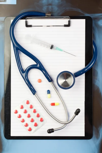 Notizblock und Blisterstreifen mit Medizin und blauem Stethoskop — Stockfoto