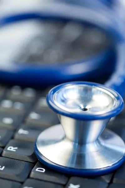 stock image Blue stethoscope in the middle of keyboard