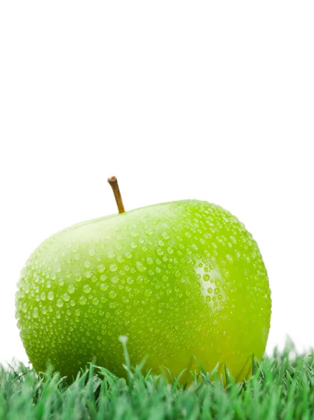 Zielone jabłko mokre na trawie — Zdjęcie stockowe