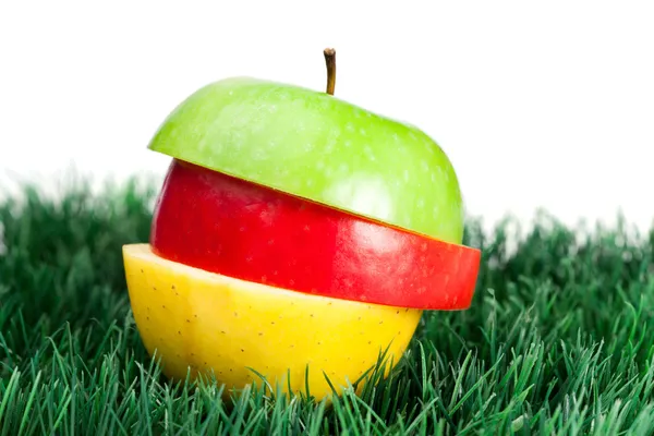 Kombinace zelené, žluté a červené jablek na trávě — Stock fotografie