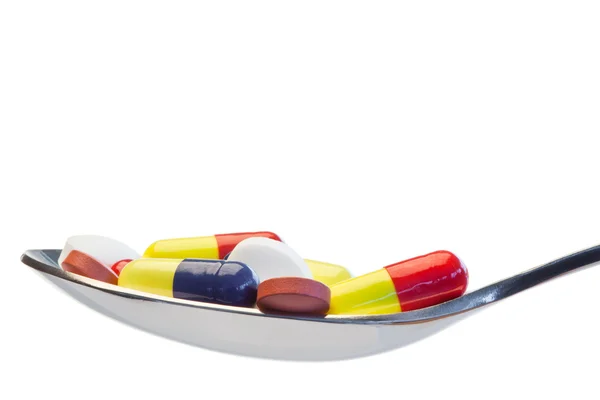 Lžíce plná barevných pilulek — Stock fotografie