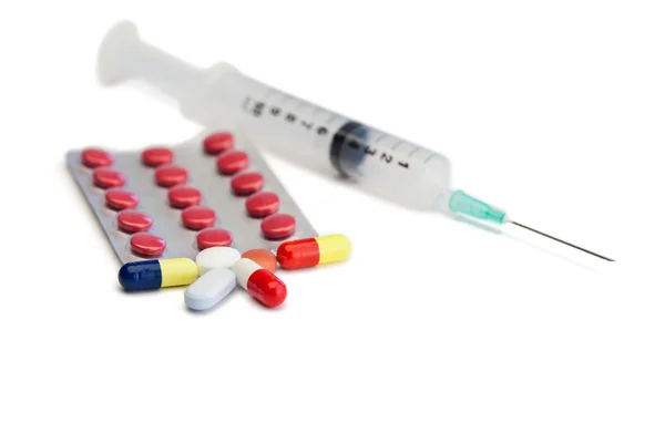 Blister strip with pills and syringe — Stock Photo, Image