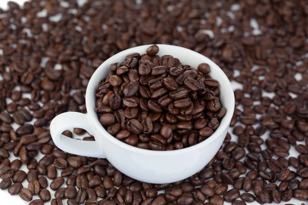 Pequena xícara branca de café com grãos de café — Fotografia de Stock