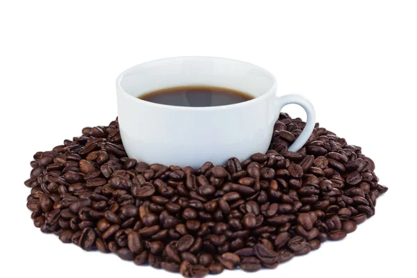 Pequena xícara de café e grãos de café — Fotografia de Stock