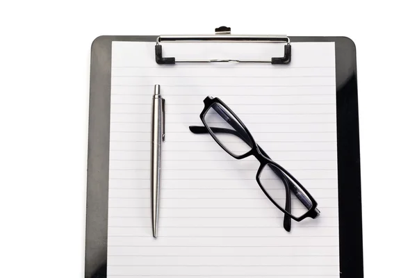 Anteckningsblock, penna och glasögon på en vit bakgrund Stockbild