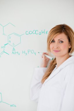 Cute female scientist looking at the camera while writing a form clipart