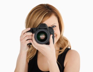 Blond-haired woman taking a photo with a camera clipart