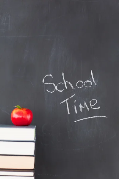 Stack of books with a red apple and a blackboard with "school ti — Stock Photo, Image