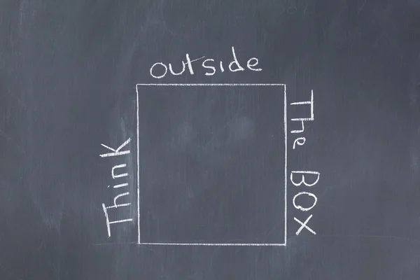 Λέξεις «σκεφτείτε έξω από το κουτί"γραμμένο γύρω από έναν κύβο σε μια blackbo — Φωτογραφία Αρχείου
