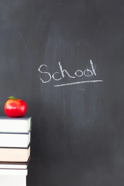 Stack of books with a red apple and a blackboard with "school" w — Stock Photo, Image