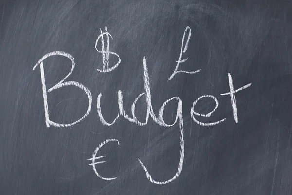 Mot "budget" et devises sur un tableau noir — Photo