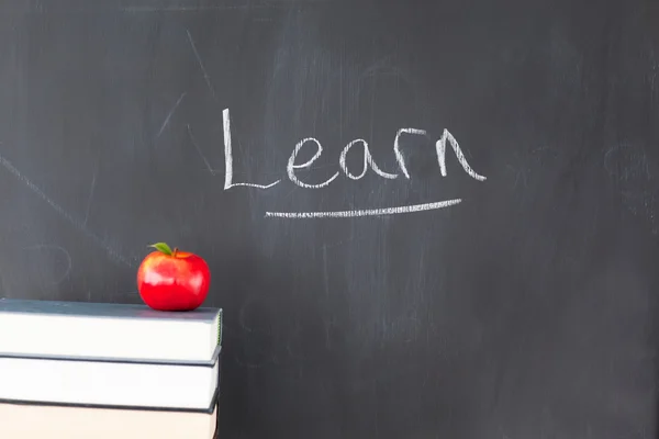 Kırmızı elma ile kitap ve yazı tahtası "öğrenmek" wr ile yığını — Stok fotoğraf