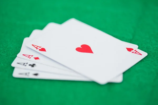 Juegos de ases de tarjeta en un playmats verde —  Fotos de Stock