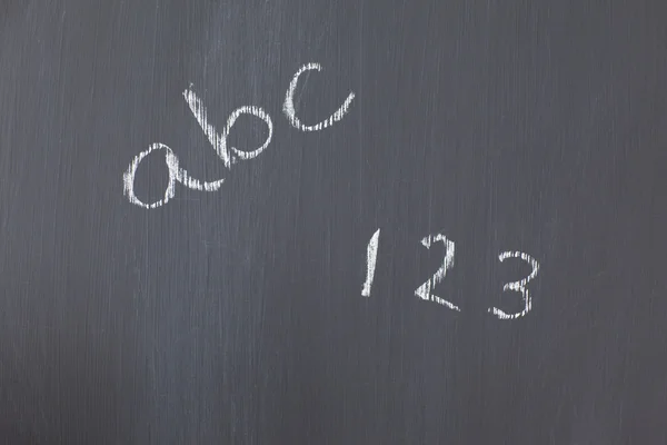 Μαυροπίνακας με αριθμούς και γράμματα, γραμμένο σε αυτό — Φωτογραφία Αρχείου