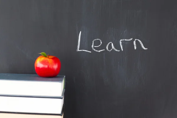 Kırmızı elma ile kitap ve yazı tahtası "öğrenmek" wr ile yığını — Stok fotoğraf