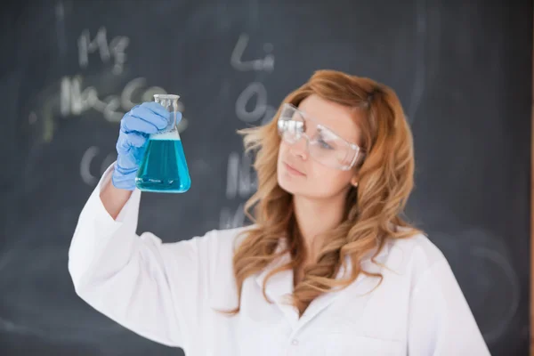 Cientista feminina a olhar para um frasco — Fotografia de Stock