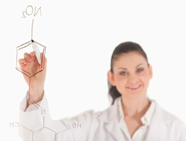 Cientista sorridente escrevendo uma fórmula em um quadro branco — Fotografia de Stock