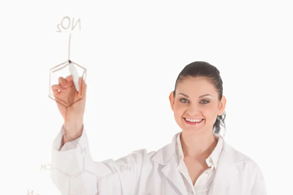 Donkerharige wetenschapper een formule schrijven op een wit bord — Stockfoto