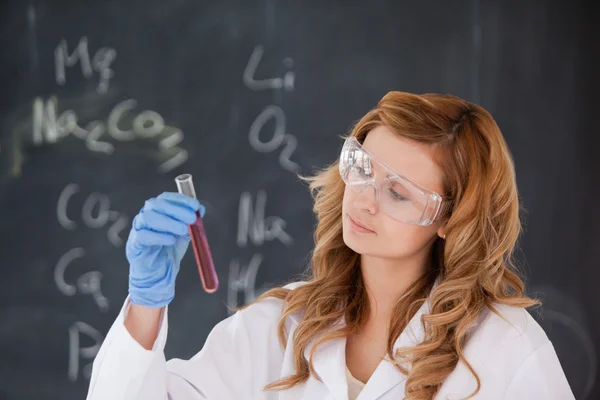 Blond-haired woman conducting an experiment — Stock Photo, Image