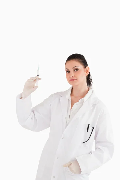 Läkaren tittar på kameran medan du håller en spruta — Stockfoto