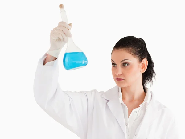 Científica de cabello oscuro mirando un frasco — Foto de Stock