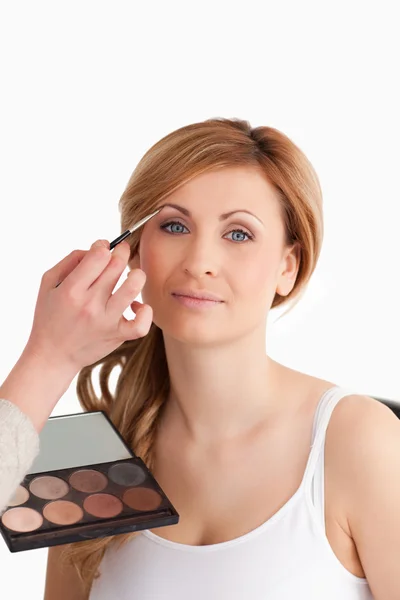 Make-up artist applying make up to a blond-haired female — Stock Photo, Image