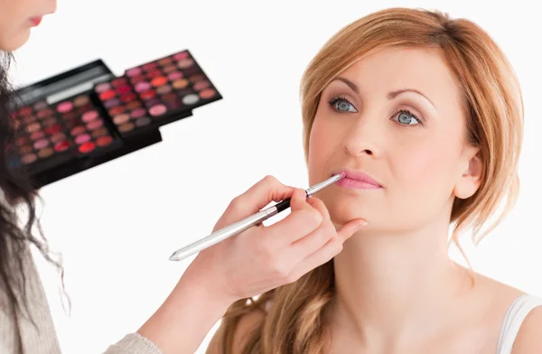 Leuke vrouw met haar make-up gedaan door een make-up artiest — Stockfoto