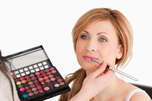 Pretty woman having her make up done by a make up artist — Stock Photo, Image