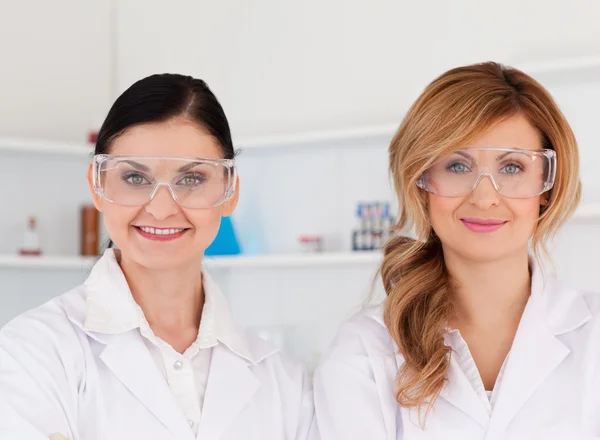 Due scienziate con occhiali di sicurezza che guardano la macchina fotografica — Foto Stock