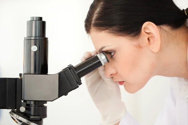 Scientist looking through a microscope — Stock Photo, Image