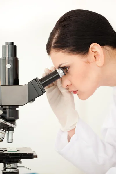 Female scientist looking through a microscope — Stock Photo, Image