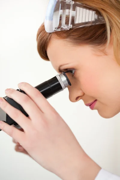 Forskare som utför ett experiment som tittar genom en microscop — Stockfoto