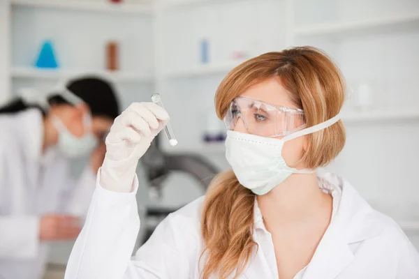 Blond-haired scientist observing a test tube — Stock Photo, Image
