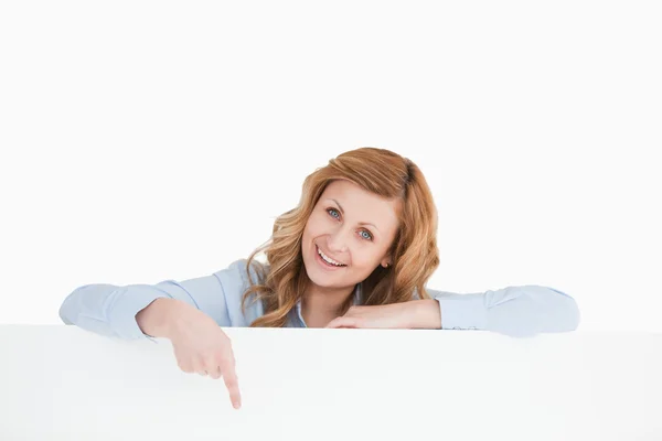 Nette blondhaarige Frau, die hinter einer leeren weißen Tafel steht — Stockfoto