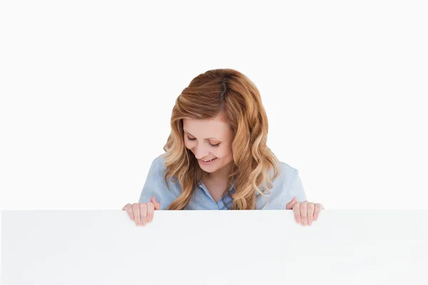Blondhaarige Frau steht hinter einer leeren weißen Tafel — Stockfoto