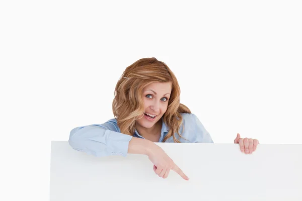 Söt blond kvinna som står bakom en vit tavla — Stockfoto