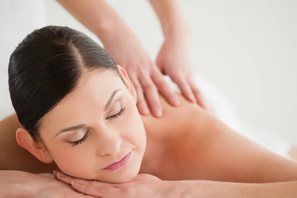 Adorável mulher de cabelos escuros desfrutando de uma massagem — Fotografia de Stock