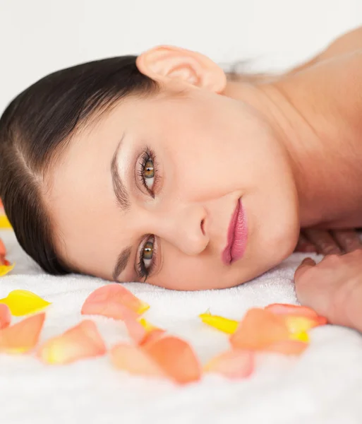 Beautiful brunette lying down and receiving a massage — Stock Photo, Image