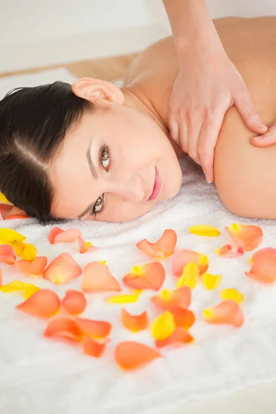 Lovely brunette lying down and getting a massage — Stock Photo, Image