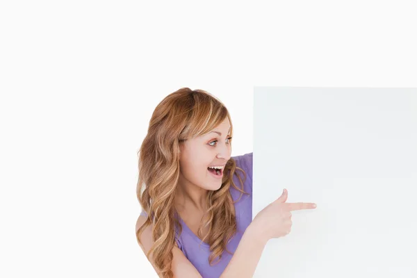 Attractive blond-haired woman holding a white board — Stock Photo, Image