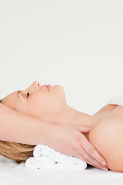 Pretty blond-haired woman lying down while receiving a spa treat — Stock Photo, Image