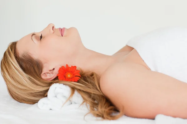 Young blond-haired woman lying down while receiving a spa treatm — Stock Photo, Image