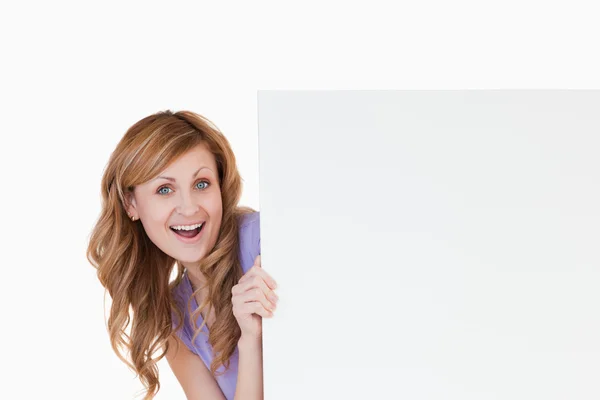 Sorrindo mulher loira de cabelos brancos segurando uma placa branca — Fotografia de Stock