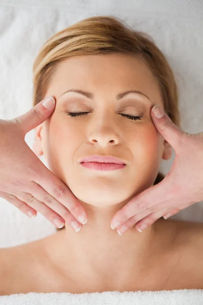 Attraktiv blond kvinna får en massage på hennes ansikte — Stockfoto