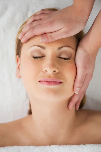 Linda loira de cabelos loiros recebendo uma massagem em seu rosto — Fotografia de Stock