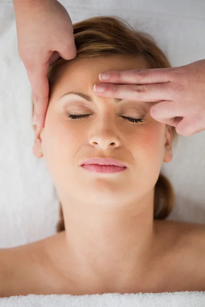 Jovem loira recebendo uma massagem em seu rosto — Fotografia de Stock