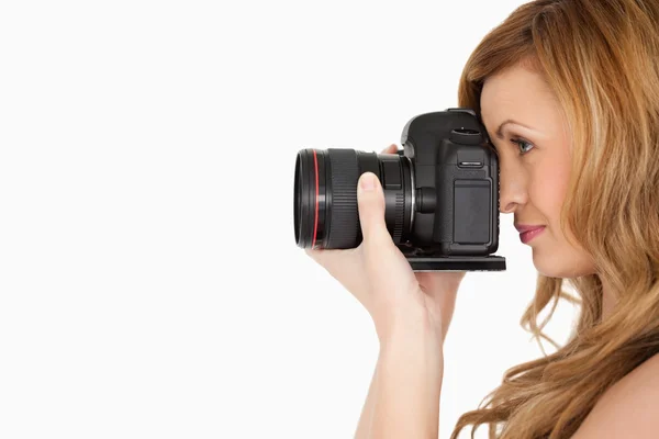 Hübsche blondhaarige Frau, die ein Foto mit einer Kamera macht — Stockfoto