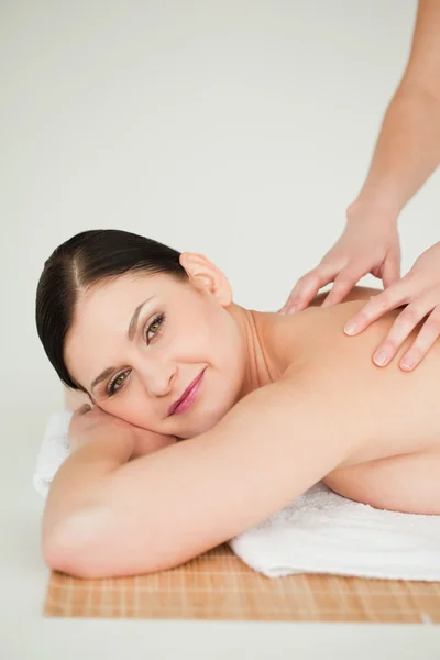 Linda morena recebendo uma massagem enquanto deitado — Fotografia de Stock
